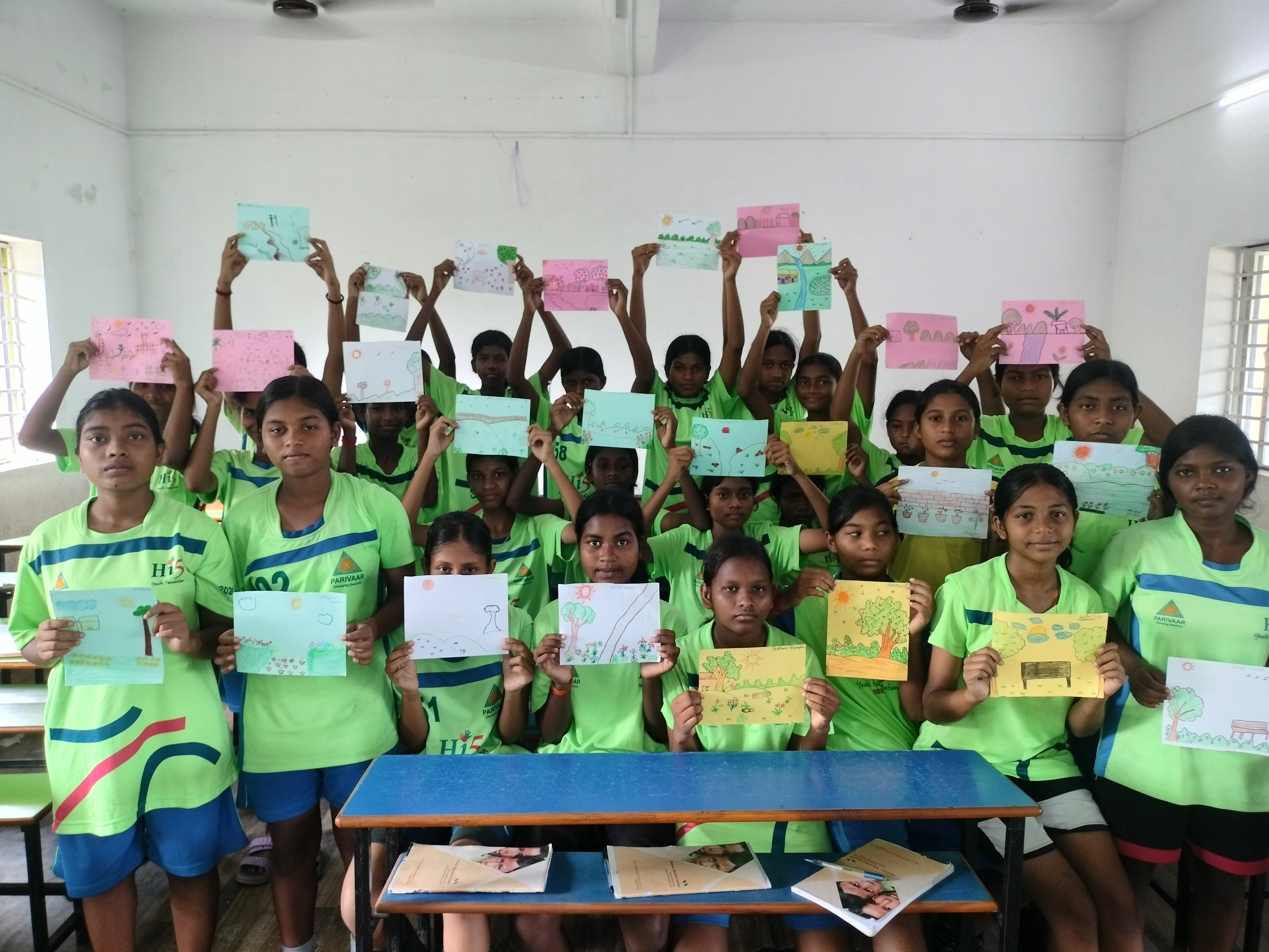 Girls holding up their English worksheets in the Pathways to Success programme