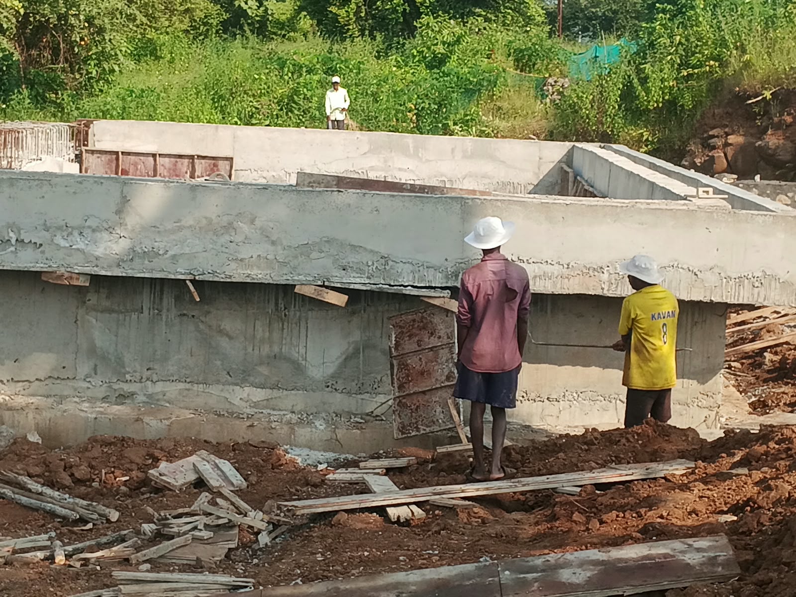 Workers building a concrete wall at the Hi 5 Basketball Academy